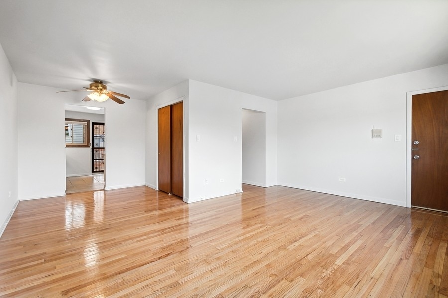 7019 North Ridge Boulevard, Unit 3B Chicago, IL 60645 - Photo 3 of 9 a view of an empty room with wooden floor and a window