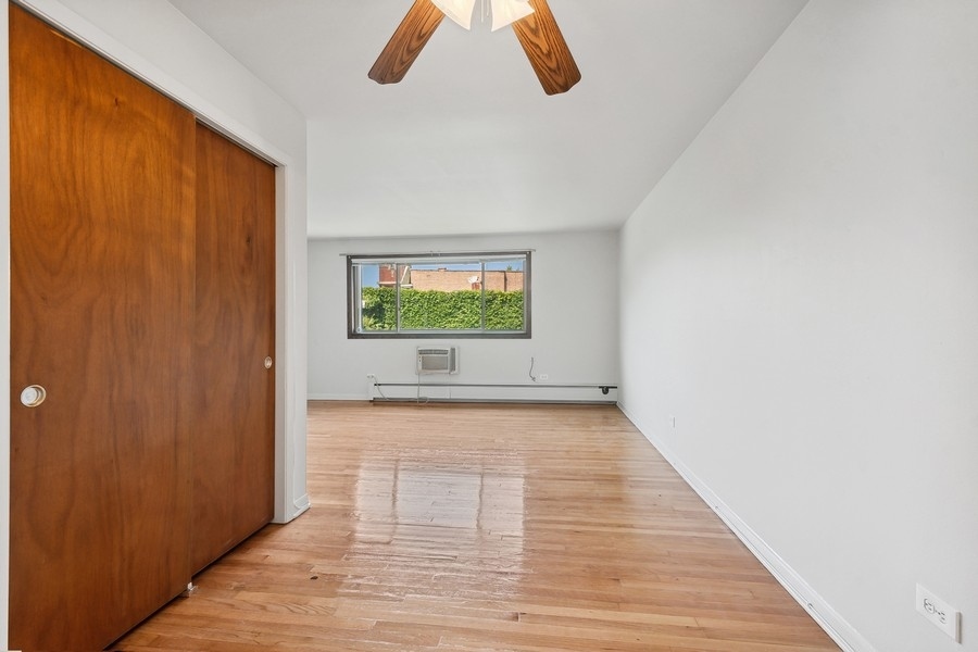 7019 North Ridge Boulevard, Unit 3B Chicago, IL 60645 - Photo 6 of 9 wooden floor in an empty room with a window