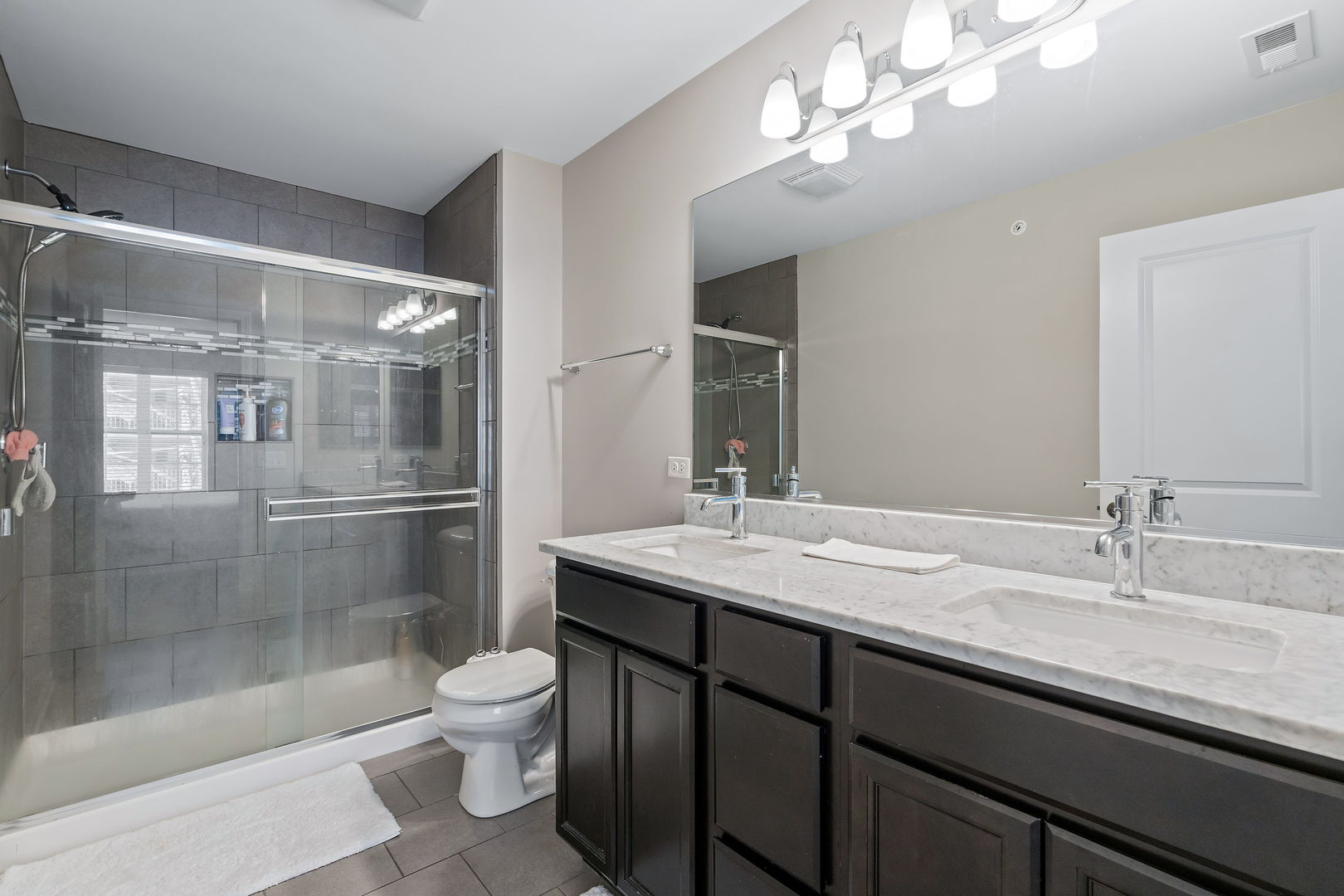 830 Center Street Des Plaines, IL 60016 - Photo 14 of 16 a bathroom with a granite countertop sink a toilet a mirror and shower