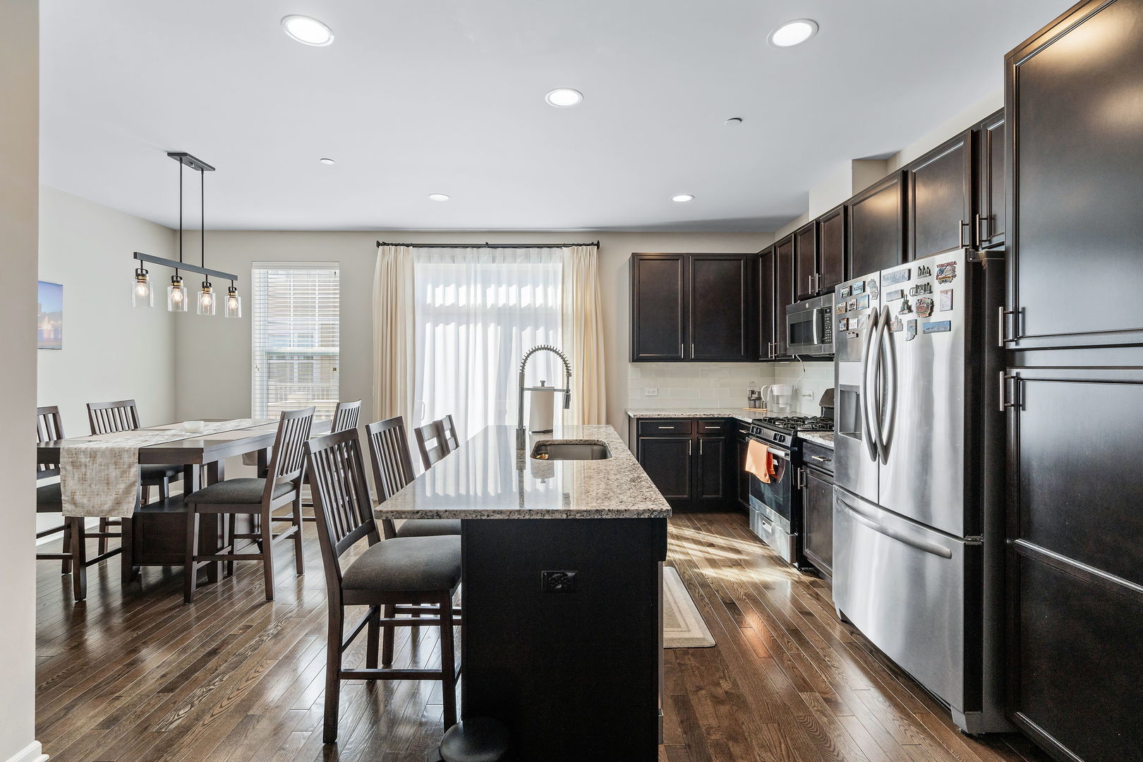 830 Center Street Des Plaines, IL 60016 - Photo 6 of 16 a kitchen with stainless steel appliances granite countertop a refrigerator a stove a sink a dining table and chairs with wooden floor