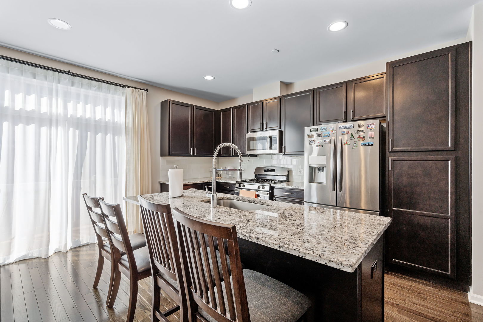 830 Center Street Des Plaines, IL 60016 - Photo 7 of 16 a kitchen with granite countertop stainless steel appliances a refrigerator a sink a stove a dining table and chairs
