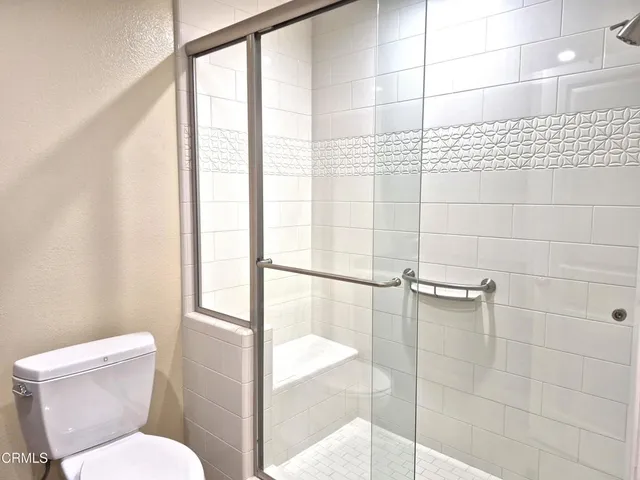 a bathroom with a toilet and a shower