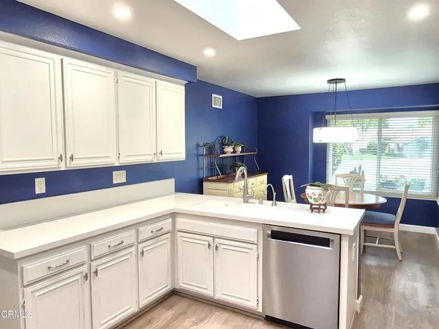 a kitchen with a sink window and cabinets