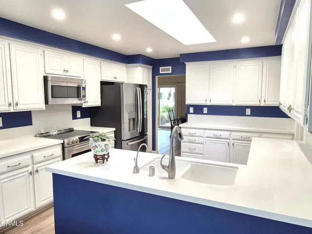 a kitchen with stainless steel appliances a microwave sink and refrigerator
