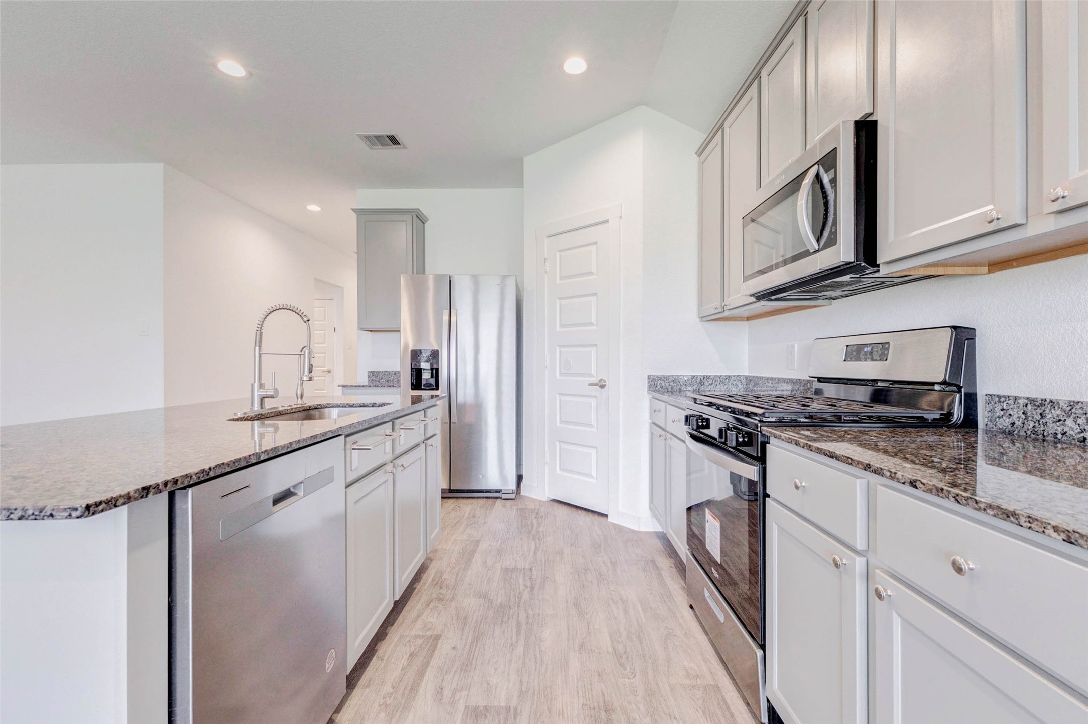 3903 Beltingham Bend Way Fulshear, TX 77441 - Photo 4 of 27 a kitchen with stainless steel appliances granite countertop a sink stove and cabinets