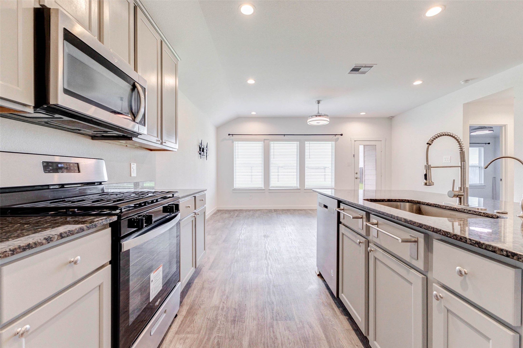 3903 Beltingham Bend Way Fulshear, TX 77441 - Photo 5 of 27 a kitchen with stainless steel appliances granite countertop wooden cabinets a stove a sink and a wooden floors