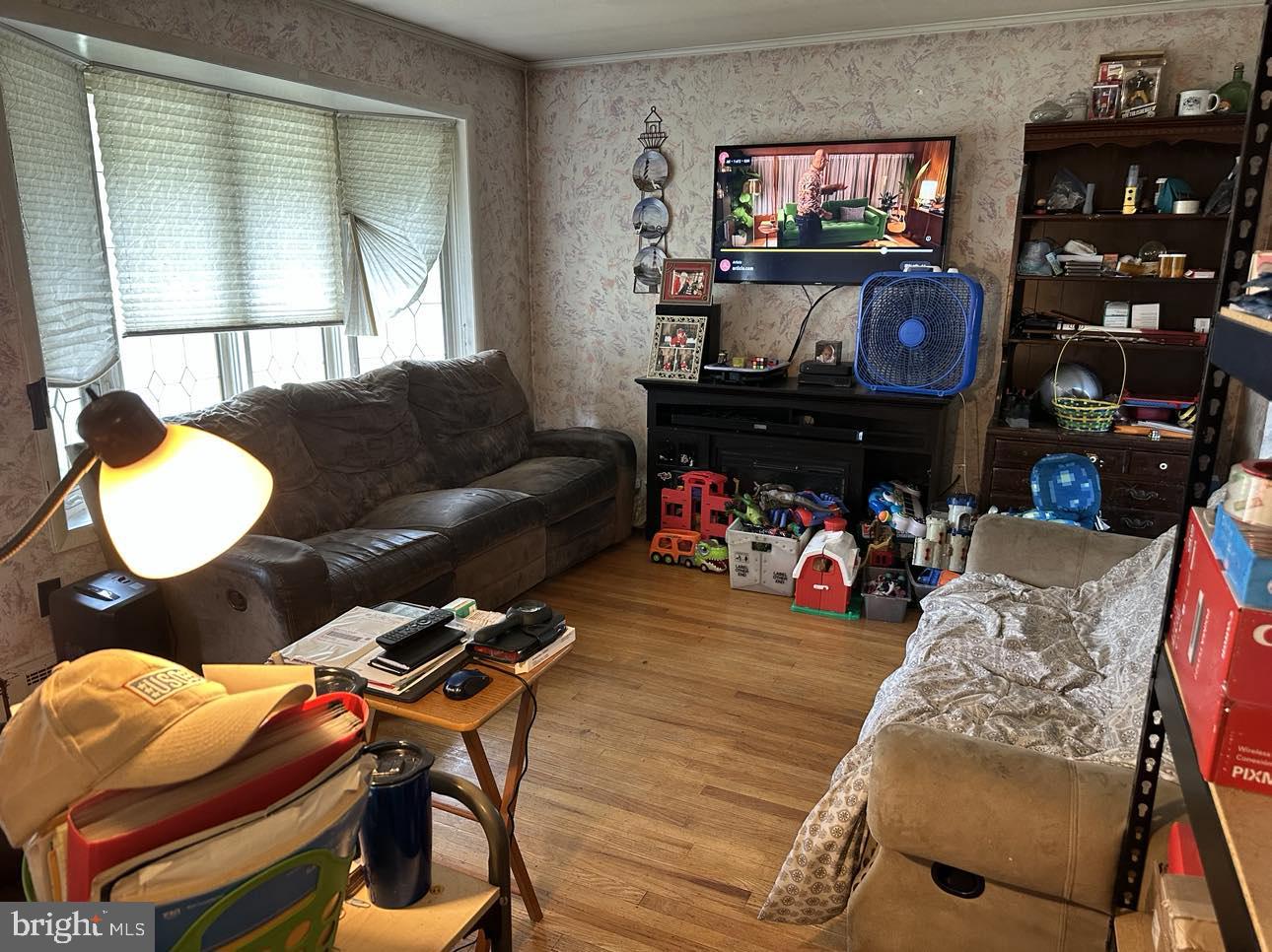 110 Centerton Road Bridgeton, NJ 08302 - Photo 4 of 21 a living room with furniture a flat screen tv and a floor to ceiling window
