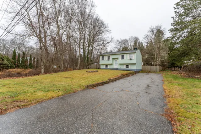 a view of a house with a yard and trees