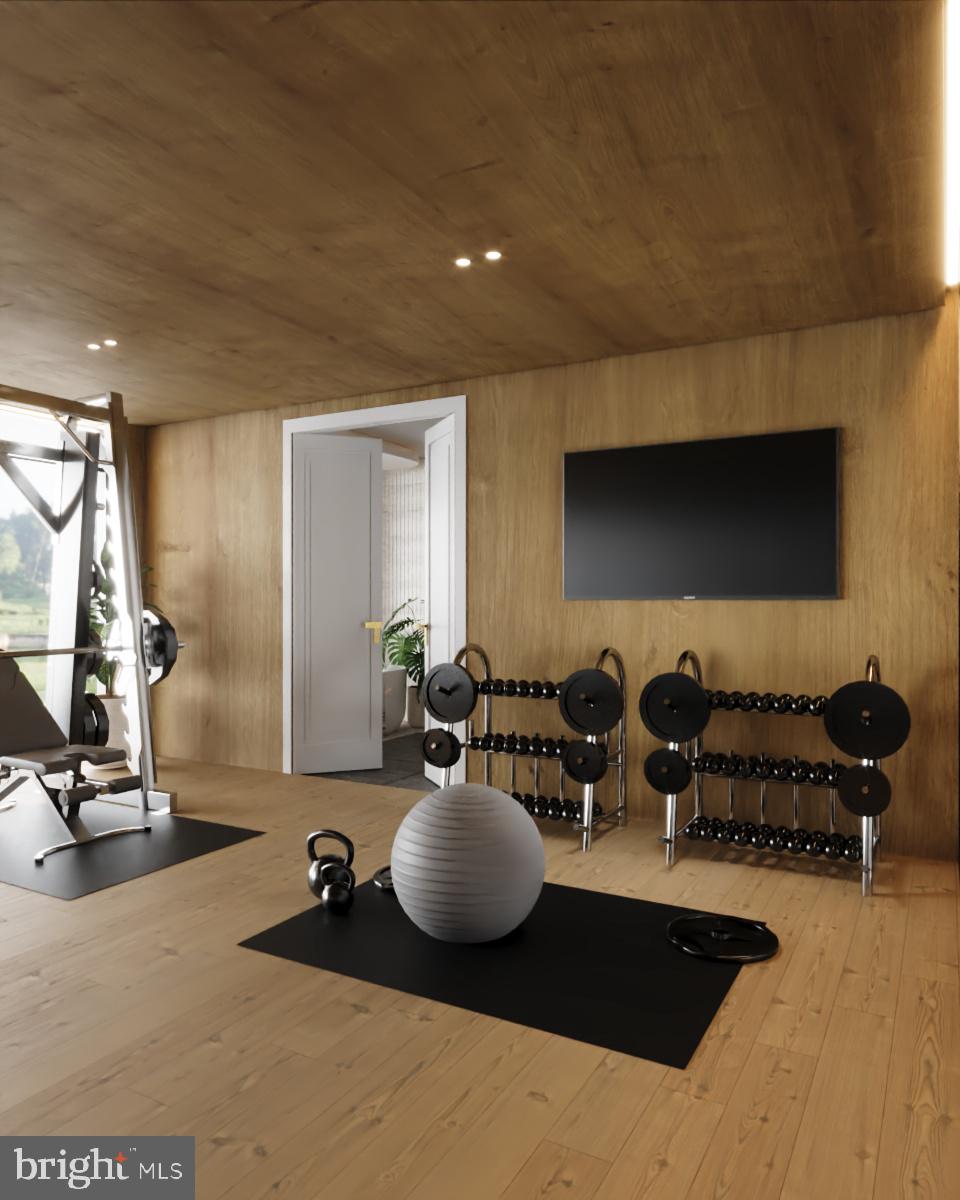 8111 Georgetown Pike McLean, VA 22102 - Photo 32 of 49 a living room with furniture a flat screen tv and gym equipment