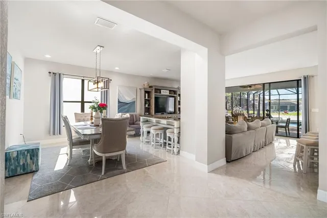 a dining room with furniture a chandelier and window