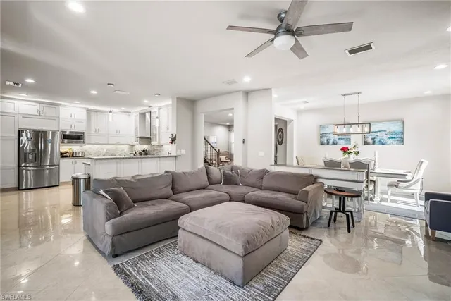 a living room kitchen with stainless steel appliances kitchen island a couches and kitchen view