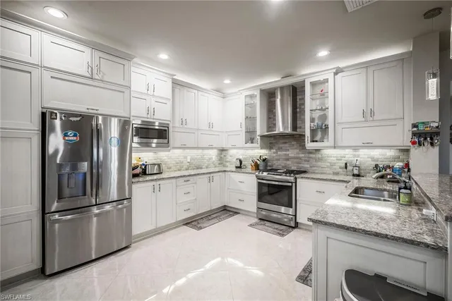 a kitchen with granite countertop stainless steel appliances and refrigerator