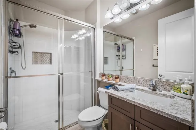 a bathroom with a granite countertop sink toilet and shower
