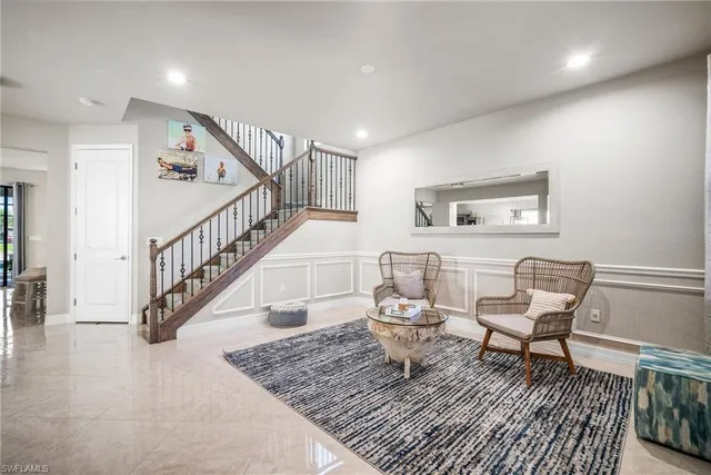 a living room with chairs and a table with wooden floor