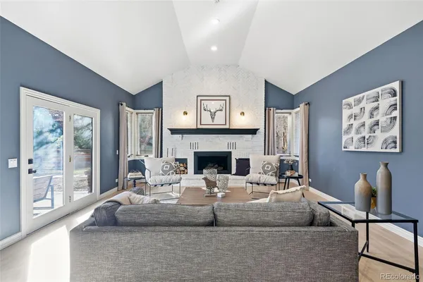 a living room with furniture a large window and a fireplace