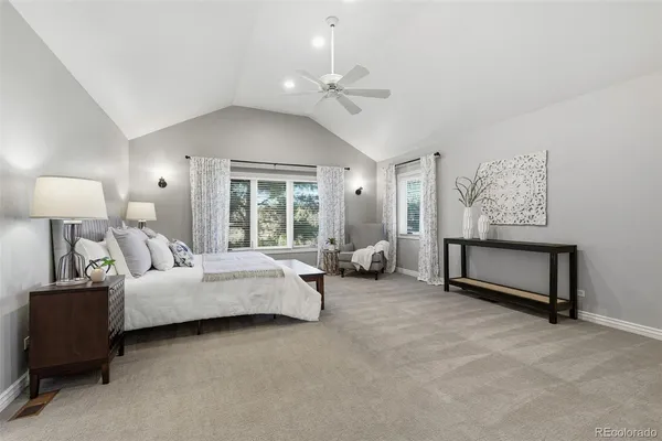 a spacious bedroom with a bed and a chandelier