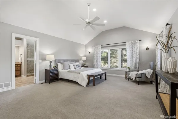 a spacious bedroom with a bed couch and a window