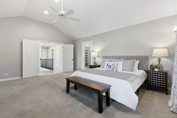 a spacious bedroom with a bed and a chandelier
