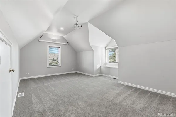 an empty room with windows and ceiling fan