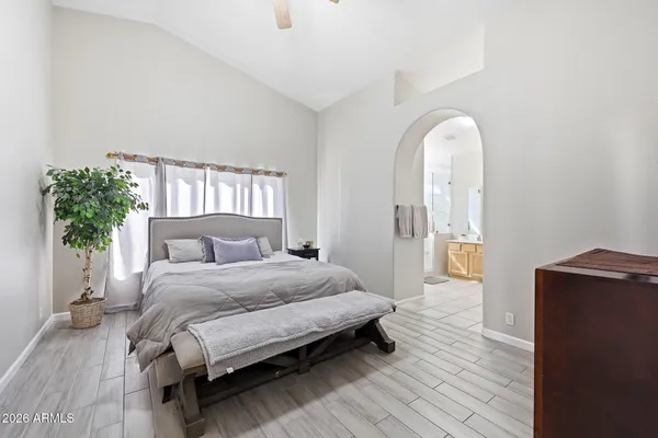 a spacious bedroom with a bed and a wooden floor