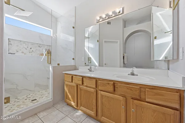a bathroom with a double vanity sink mirror and shower