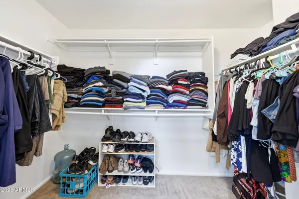a view of walk in closet with clothes and shoes