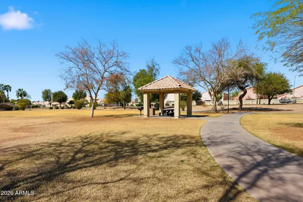 a view of a swimming pool with lawn chairs under an umbrella