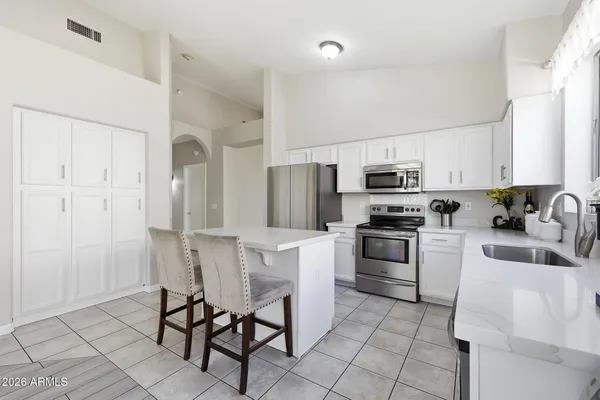a kitchen with cabinets stainless steel appliances and a counter top space