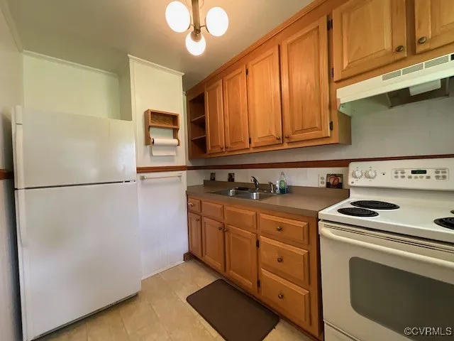 a kitchen with stainless steel appliances granite countertop a refrigerator a stove a sink and a microwave