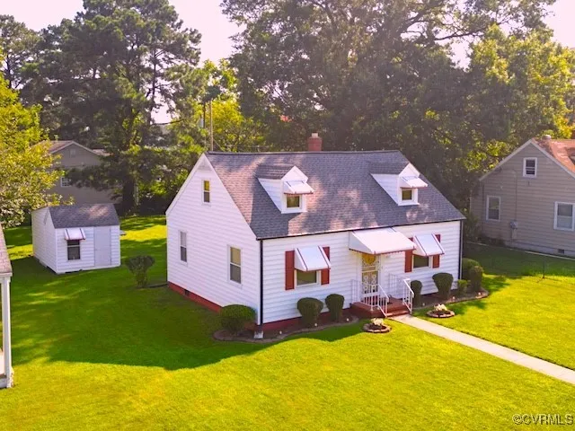 a view of a house with a big yard and large tree