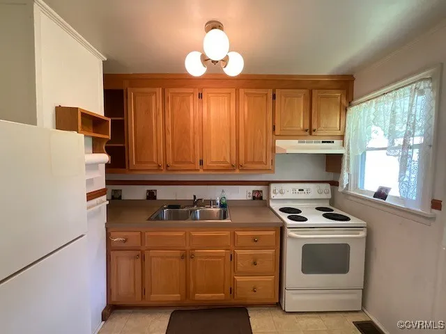 a kitchen with stainless steel appliances granite countertop a sink a stove and a refrigerator