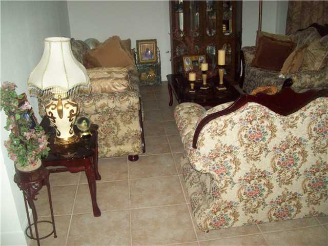 613 Southwest Homeland Road Port St. Lucie, FL 34953 - Photo 4 of 4 a bed room with a bed and a chair