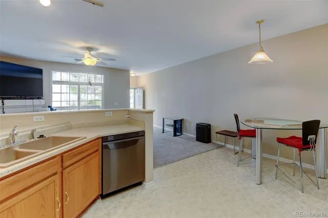 a living room with furniture a flat screen tv and kitchen view