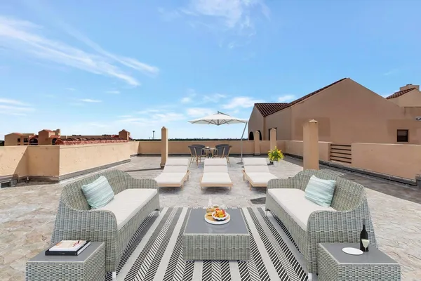 a view of a roof deck with couches and sky view