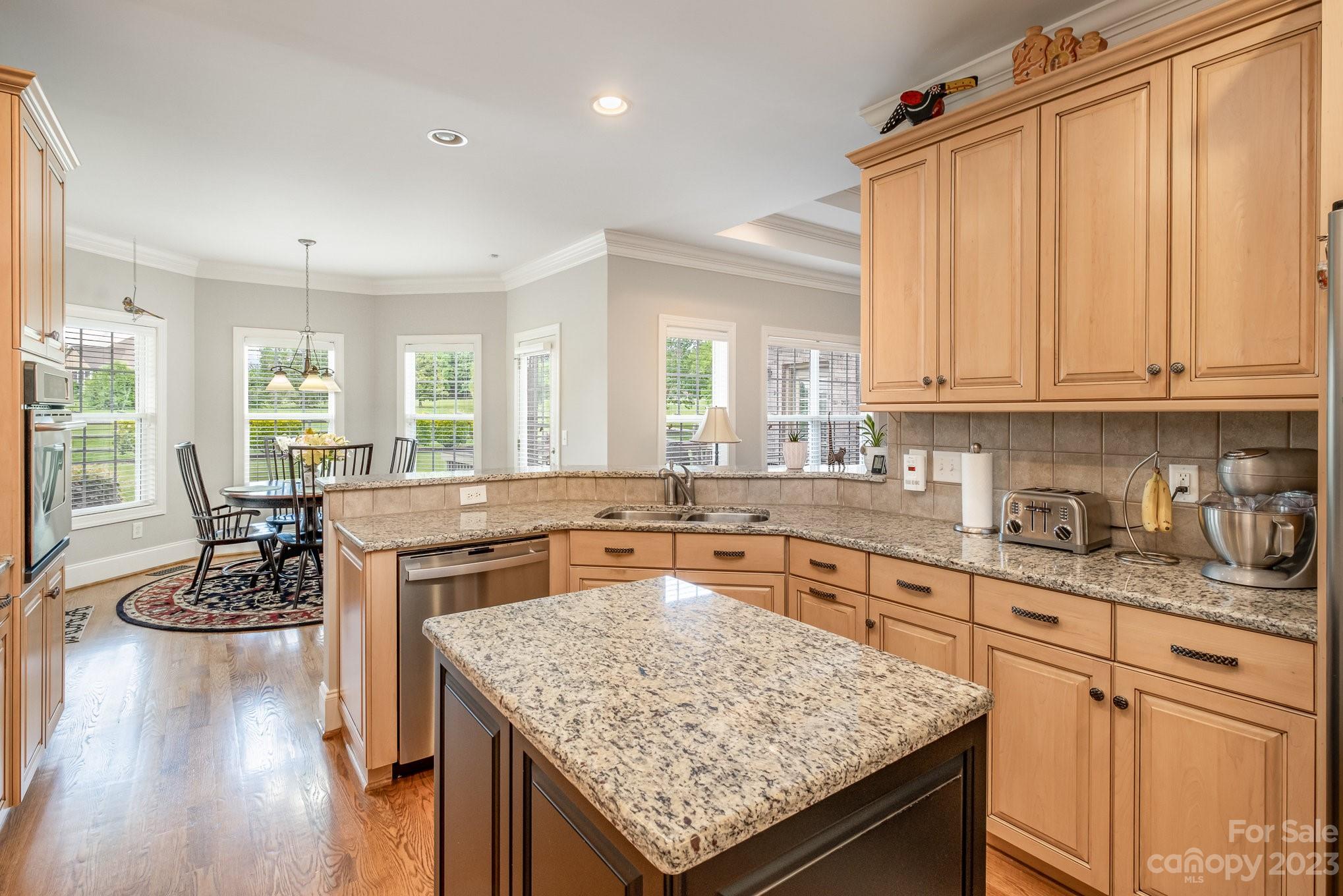 4733 Campobello Drive Monroe, NC 28110 - Photo 16 of 43 a kitchen with a stove a sink dishwasher a dining table and chairs with wooden floor