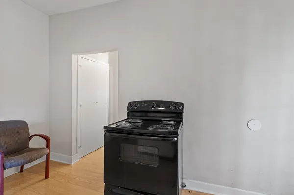 a view of kitchen with stove top oven and cabinets