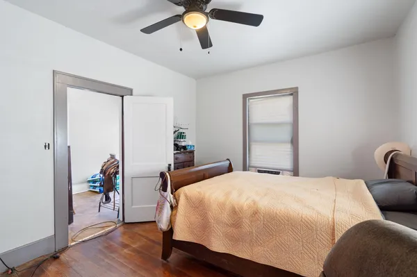 a bedroom with a bed and wooden floor
