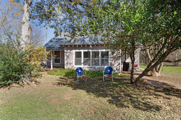 a view of a house with a yard and sitting area