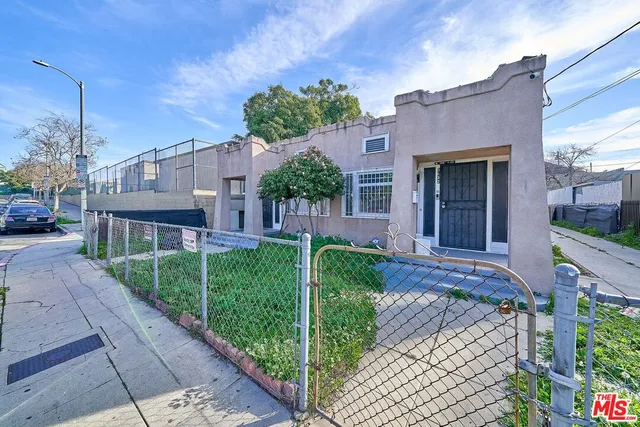 a view of a yard with wooden fence