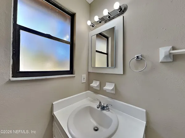 a bathroom with a sink mirror and vanity