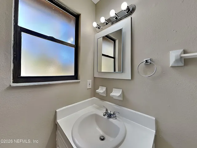 a bathroom with a sink mirror and vanity