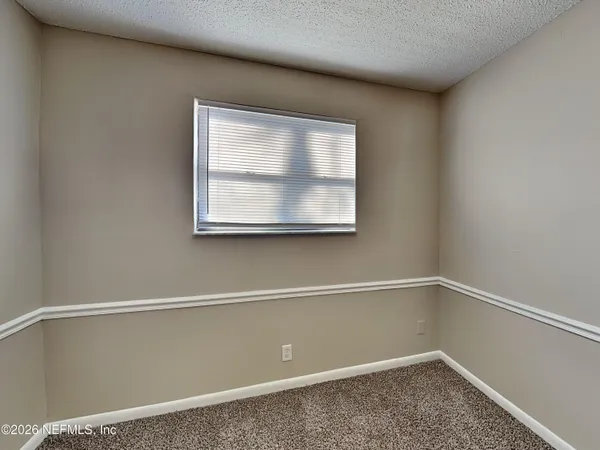a view of a small space with wooden floor and a window