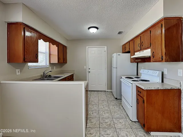 a kitchen with granite countertop a sink stainless steel appliances and cabinets
