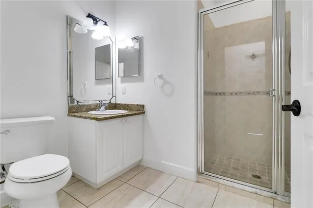 a bathroom with a granite countertop sink a toilet and shower