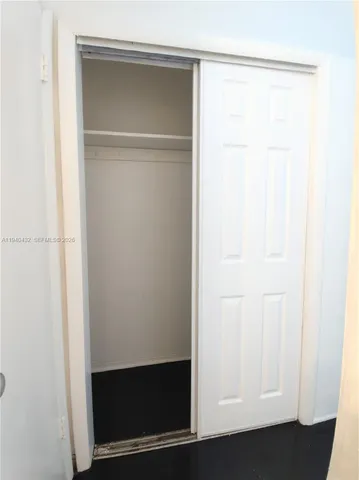 a walk in closet with wooden floor