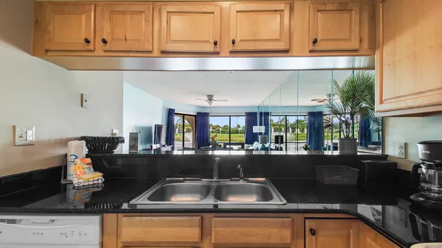 a kitchen with stainless steel appliances granite countertop a stove a refrigerator a dining table and chairs with wooden floor