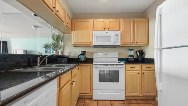a kitchen with stainless steel appliances granite countertop a sink a stove and cabinets