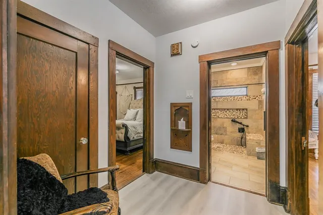 a view of a hallway with bathroom and glass door