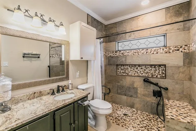 a bathroom with a sink a toilet and shower