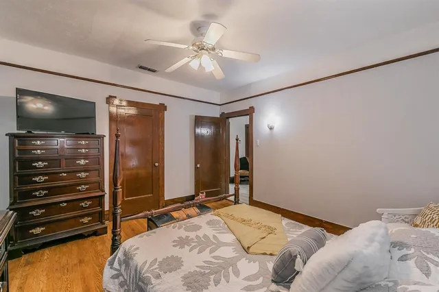 a bedroom with a bed and a flat tv screen on dresser